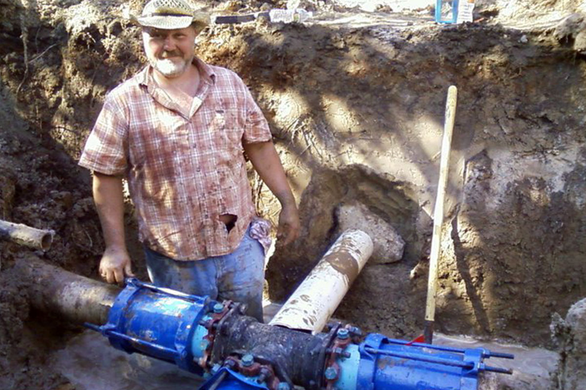 a worker from Angelina water repairing a water line in a pit.